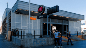 Exterior en colores de la estación Franklin salida de la línea 2. Hay personas saliendo del metro.